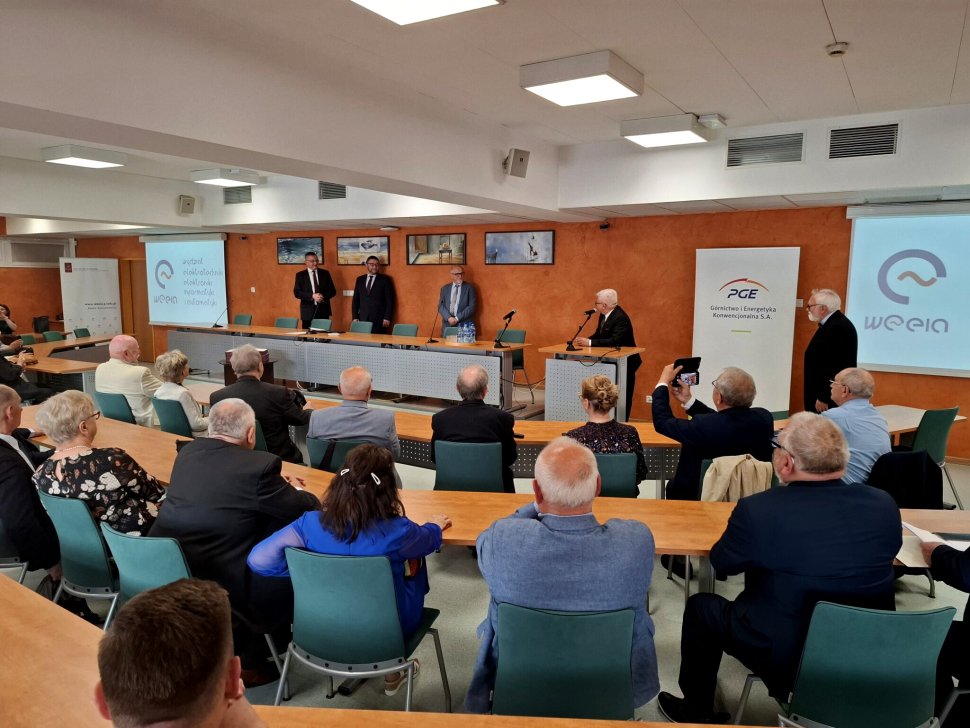 Grupa absolwentów Wydziału Elektrycznego z rocznika 1976 siedząca w sali konferencyjnej podczas uroczystości rozdania Złotych Dyplomów 