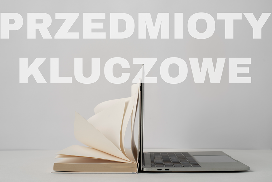 Książka i laptop na jasnym tle. Nad nimi napis "przedmioty kluczowe".