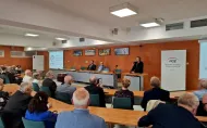 Grupa absolwentów Wydziału Elektrycznego z rocznika 1976 siedząca w sali konferencyjnej podczas uroczystości rozdania Złotych Dyplomów 