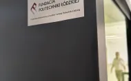 Zdjęcie budki akustycznej dla studentów z antracytową obudową, zielonym wnętrzem, białym blatem stolika.