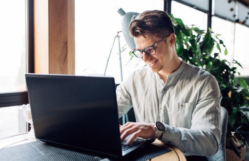 attractive-businessman-eyeglasses-working-laptop-typing-spending-time-cafe.jpg