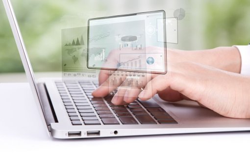 Fragment klawiatury laptopa i dłonie nad nimi.